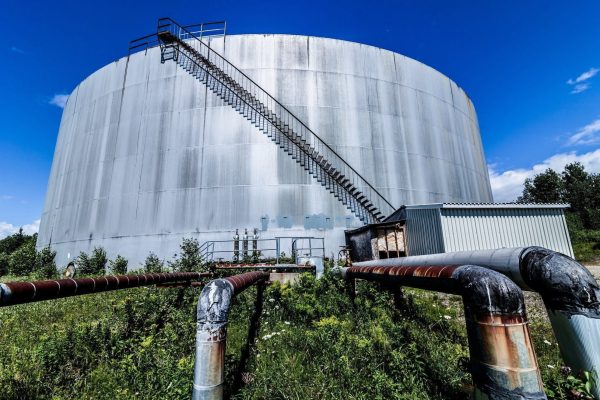 Abandoned Oil Refinery Gas Tank and Rusty Pipeline